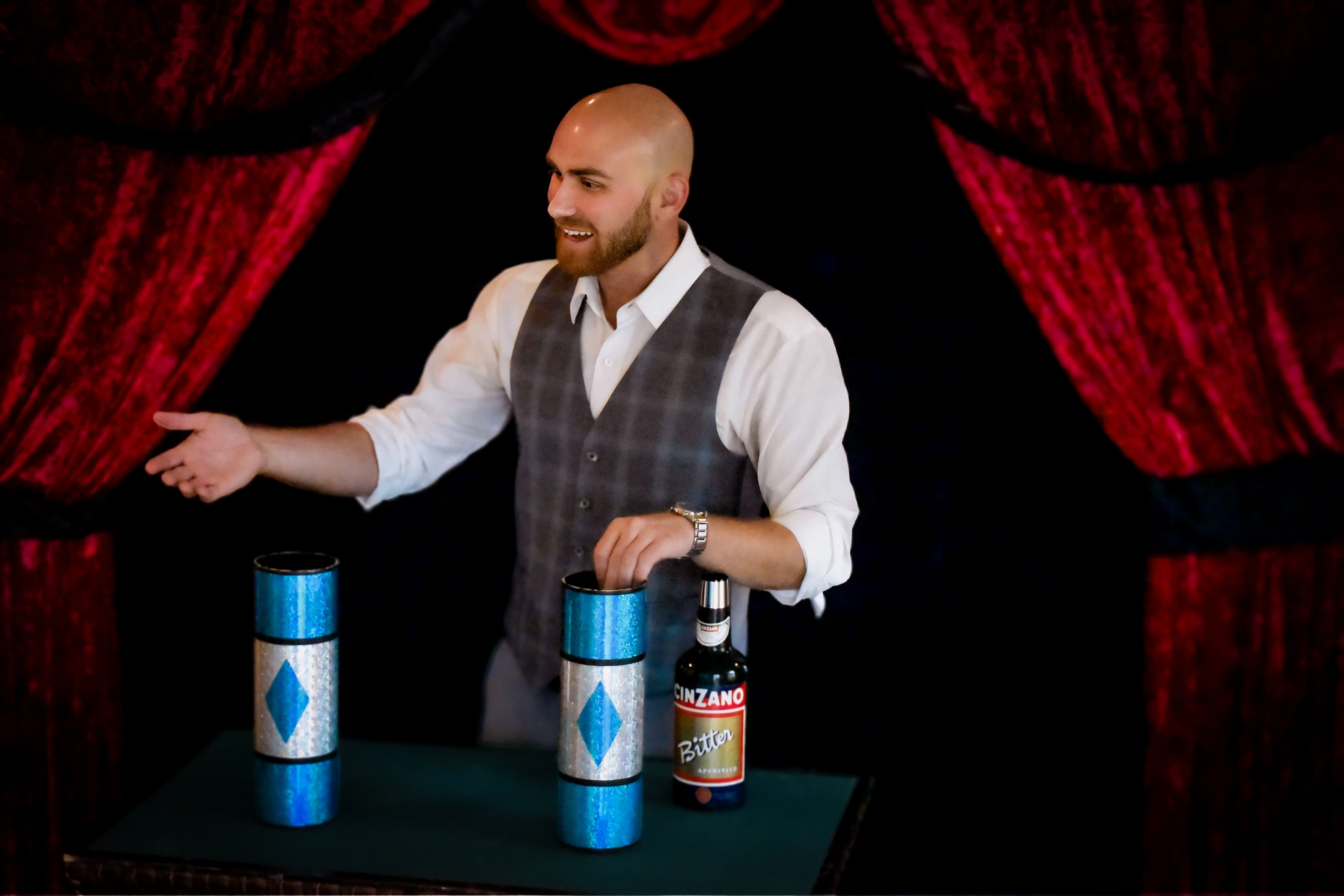 Dylan Looper performing a stage illusion with cups and a bottle