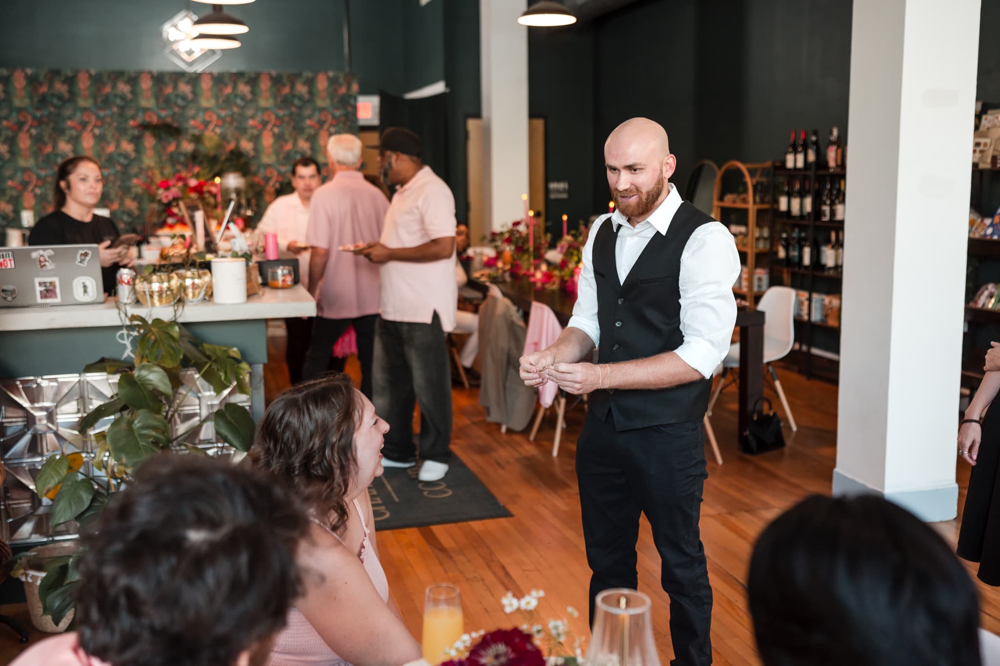 Dylan Looper performing roaming magic near the bar at a wedding reception