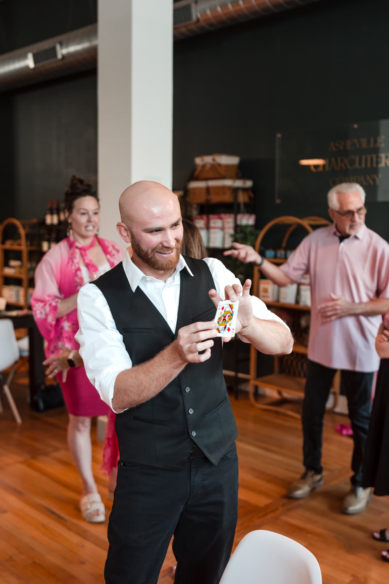 Dylan Looper smiling while revealing a card trick to wedding guests