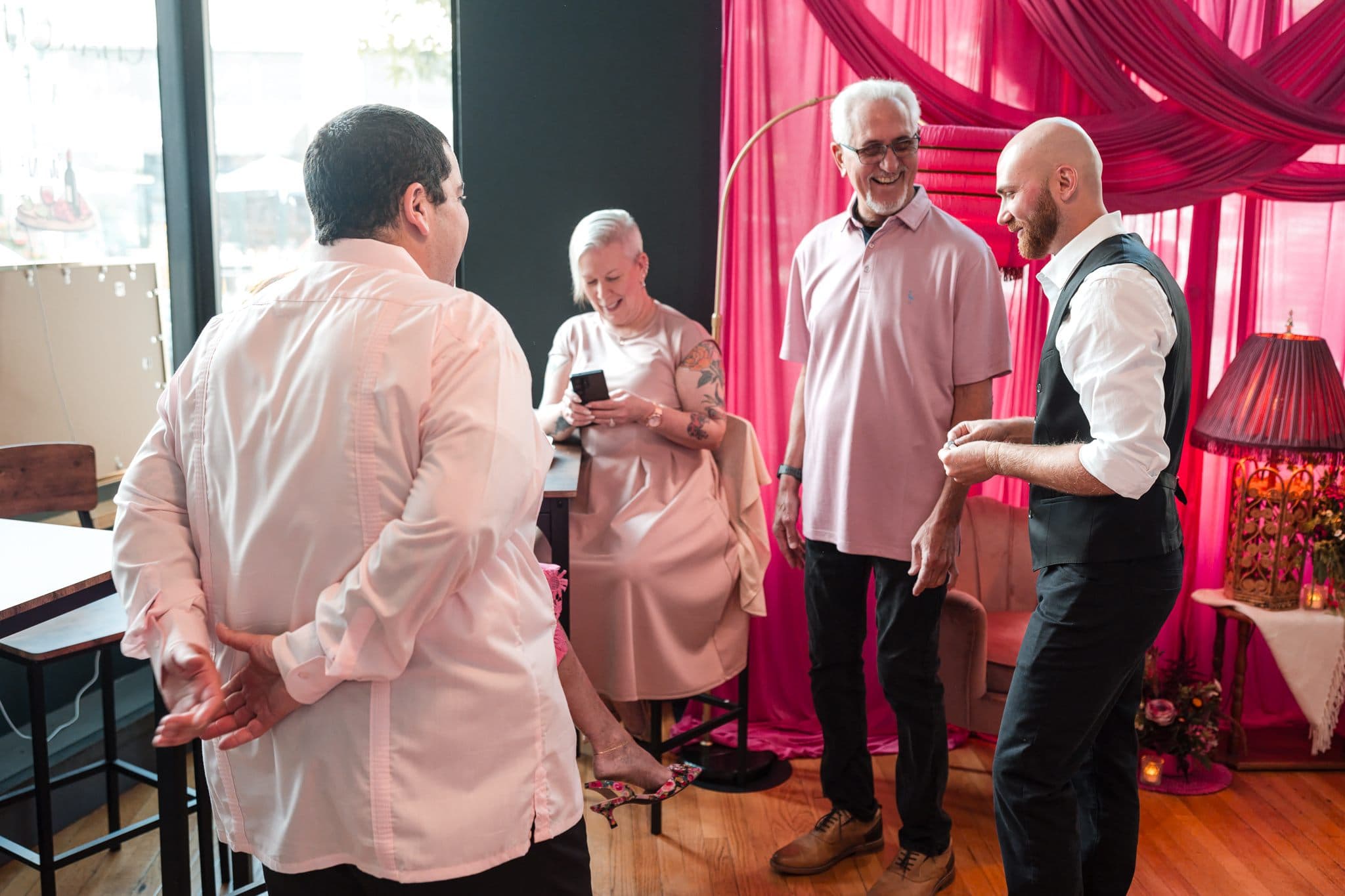 Wedding guests laughing together with Dylan Looper during cocktail hour magic